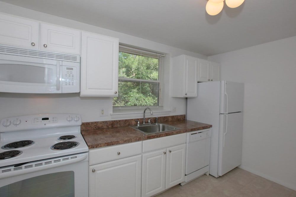 White cabinets in the kitchen with matching white appliances for an easy clean at Eagle Rock Apartments at West Hartford in West Hartford, Connecticut