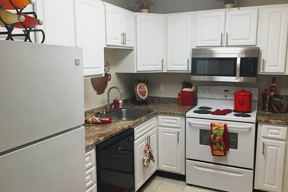 Kitchen area with white cabinets and appliances and a light brown counter top at Berkshire 54 in Carrboro, North Carolina