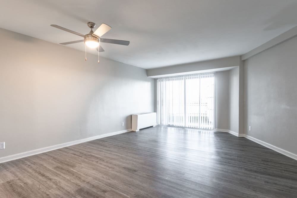 Massive open living room area with ceiling fan and large sliding glass door at Pembroke Towers in Norfolk, Virginia