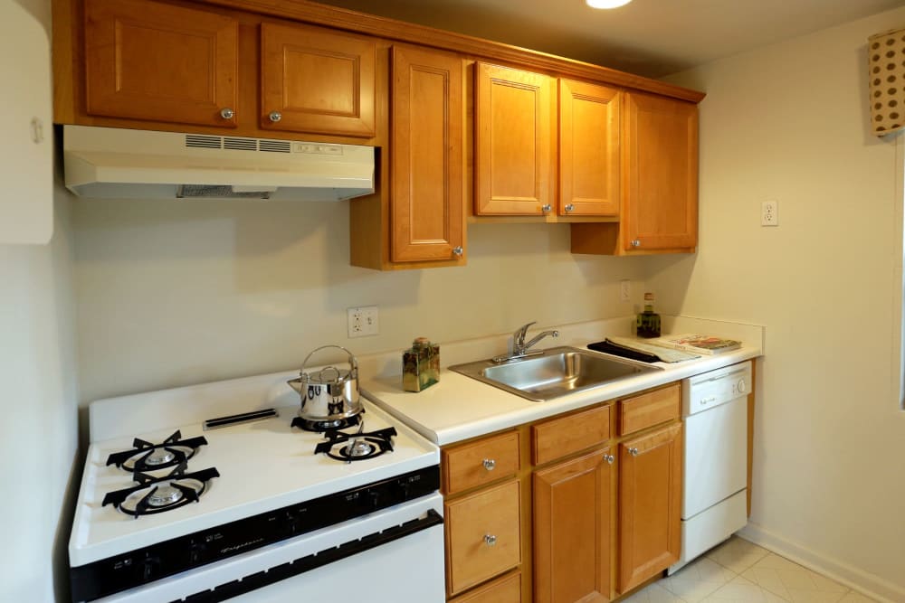 Light wood cabinets and white appliances in the kitchen at Brookchester Apartments in New Milford, New Jersey