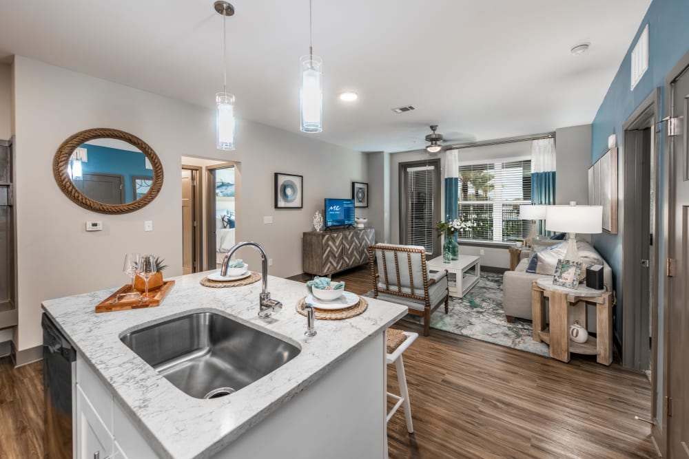 An open-concept floor plan with the kitchen overlooking the living room at Olympus Emerald Coast in Destin, Florida