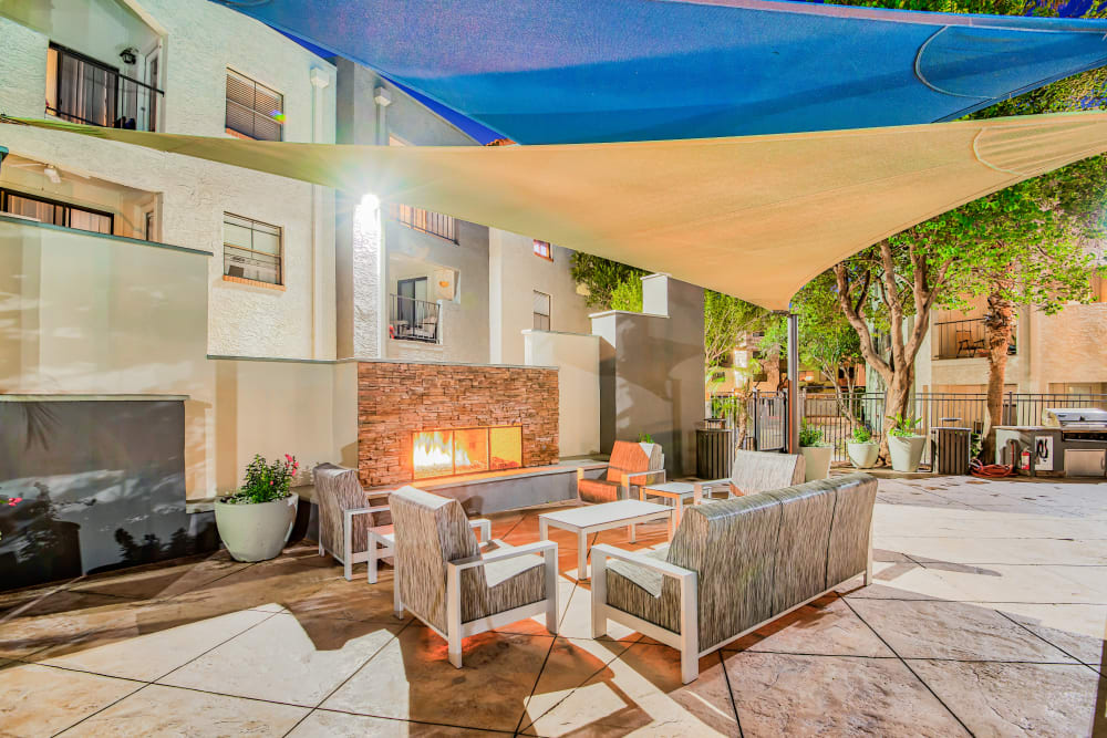 Outdoor covered lounge area with a fireplace at Greenspoint at Paradise Valley in Phoenix, Arizona