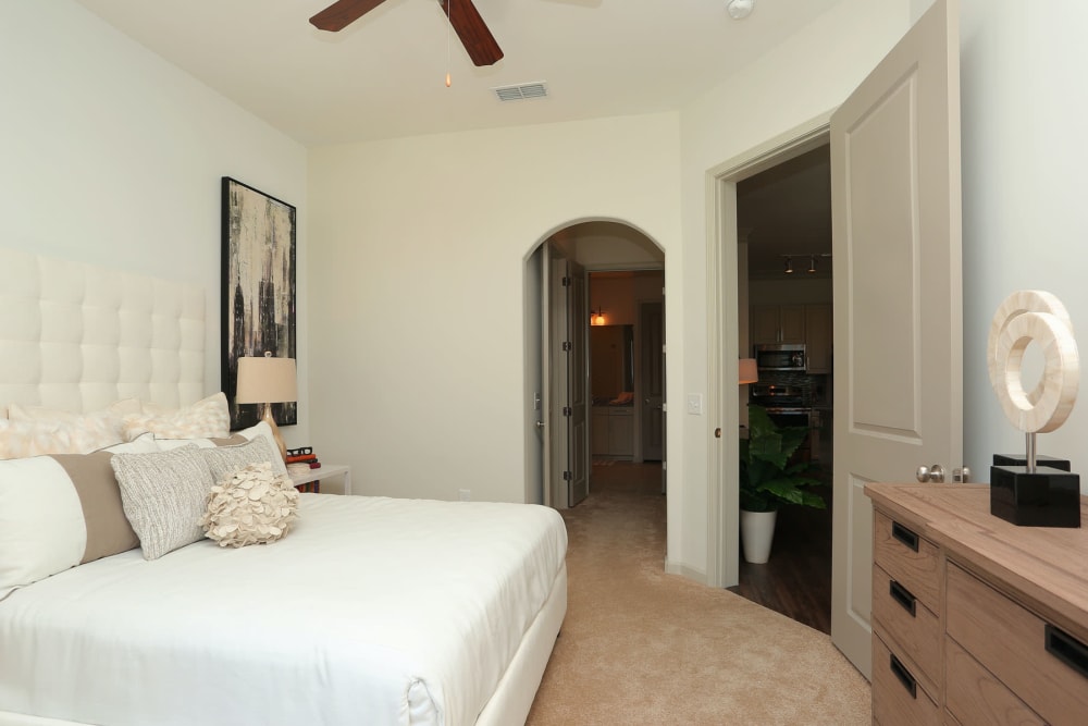 Ceiling fan and modern furnishings in the primary bedroom of a model apartment at 2370 Main at Sugarloaf in Duluth, Georgia