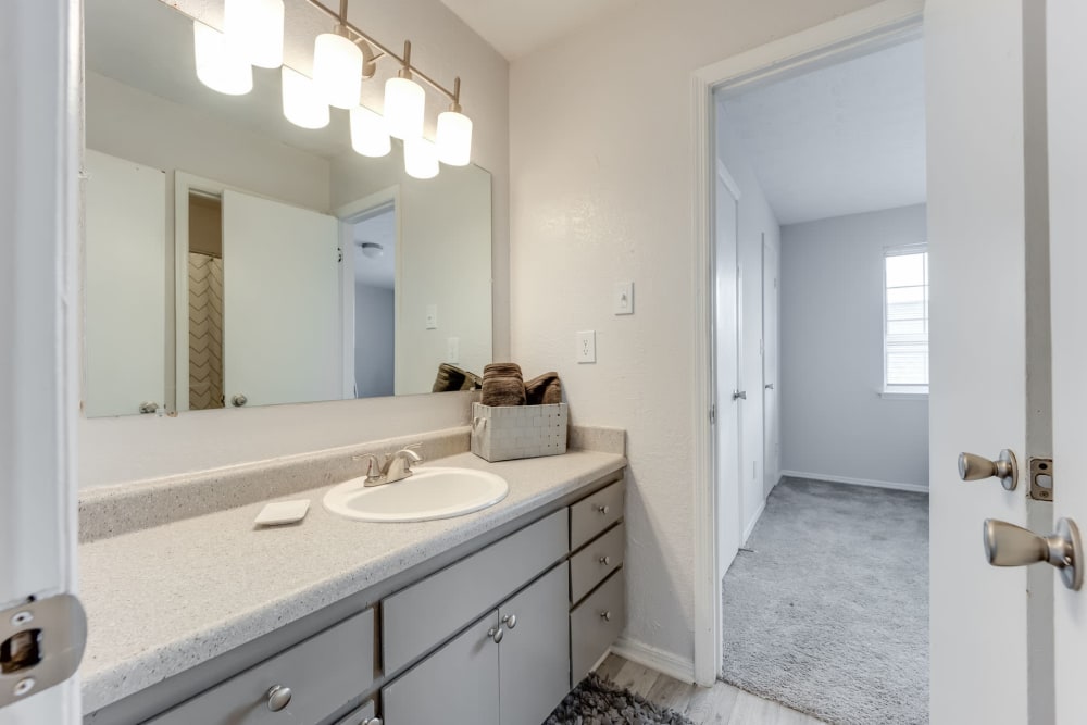 Ample countertop space and a large vanity mirror in an apartment home's bathroom at Sedgefield in Marietta, Georgia