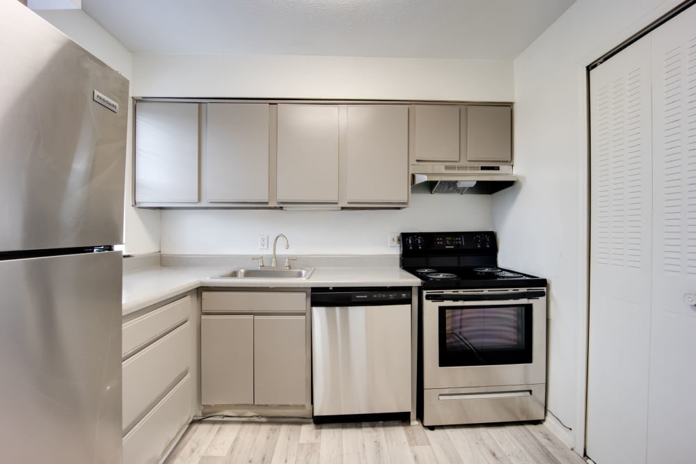 Stainless-steel appliances and hardwood-style flooring in an apartment's kitchen at Sedgefield in Marietta, Georgia