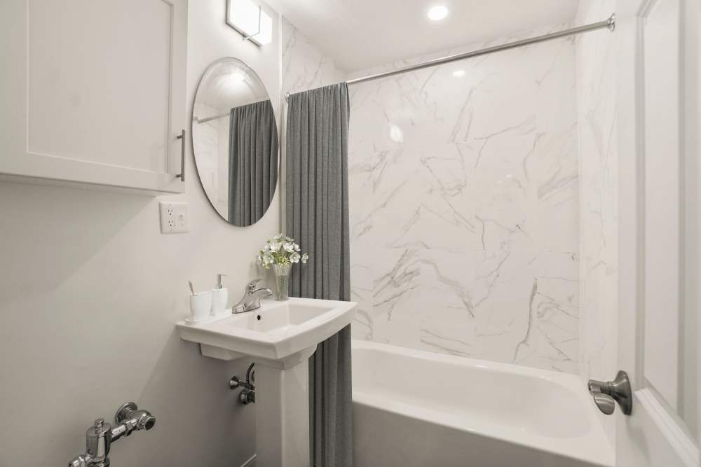 Bathroom with custom backsplash and vanity lights at Camelot Court in Brighton, Massachusetts
