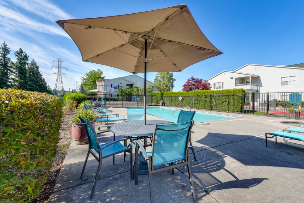 Beautiful resort-style swimming pool with lounge chairs at The Landings at Morrison Apartments in Gresham, Oregon
