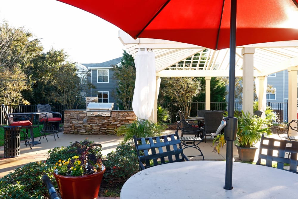 Table with Seating and an Umbrella near BBQ Area at The Seasons at Umstead in Raleigh, North Carolina