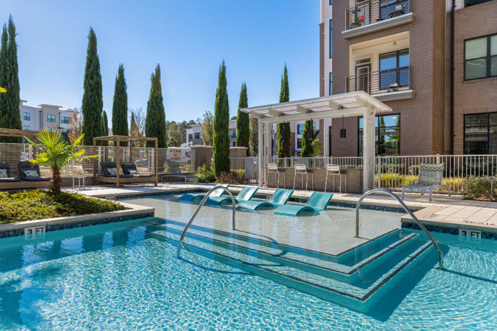 Sparkling resort style pool with deck lounge chairs at Marq at Crabtree in Raleigh, North Carolina