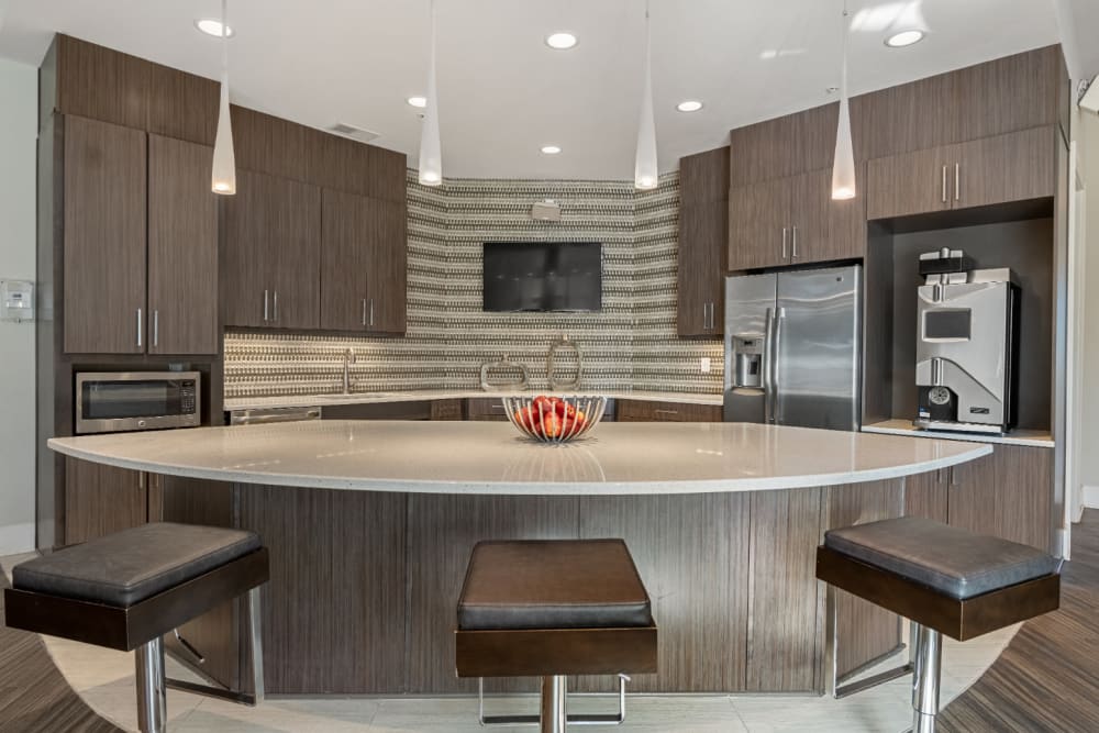 Modern style community kitchen with adjustable counter stools at Marq at Crabtree in Raleigh, North Carolina