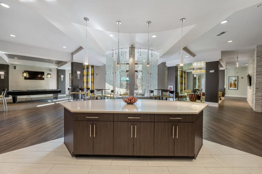 Modern and sleek community clubhouse with kitchen, seating, and dining areas at Marq at Crabtree in Raleigh, North Carolina