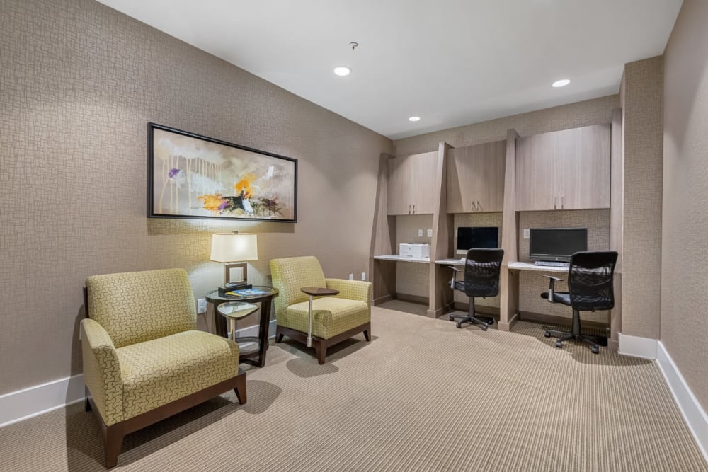 Business workstations with printer and cushioned desk chairs nearby at Marq at Crabtree in Raleigh, North Carolina