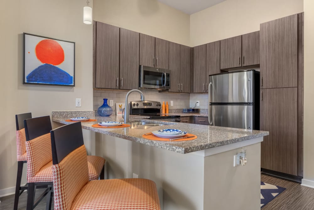 Bright kitchen with counter stool chairs and granite countertops at Marq at Crabtree in Raleigh, North Carolina