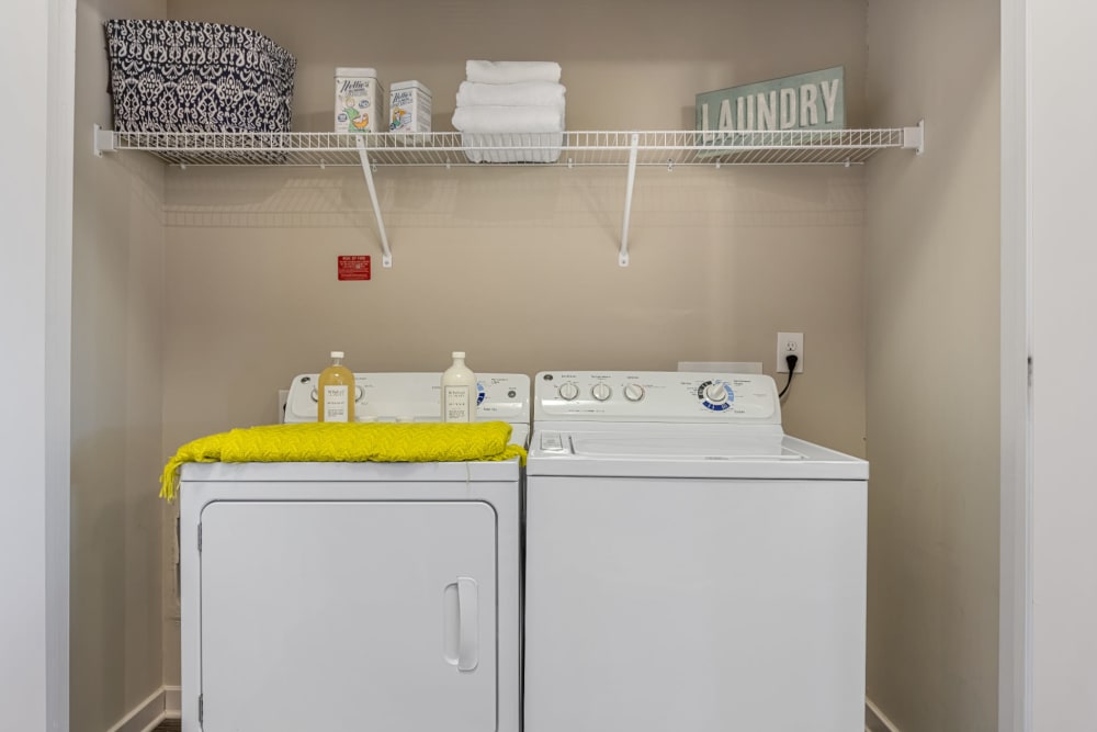 Laundry nook with full size washer and dryer and wired shelving at Marq at Crabtree in Raleigh, North Carolina
