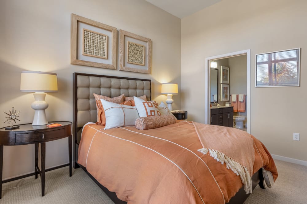 Bright and cozy bedroom with large bed, side tables, and private bathroom at Marq at Crabtree in Raleigh, North Carolina