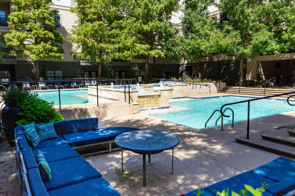 Lounge couches next to sparkling pool at Marquis at Texas Street in Dallas, Texas