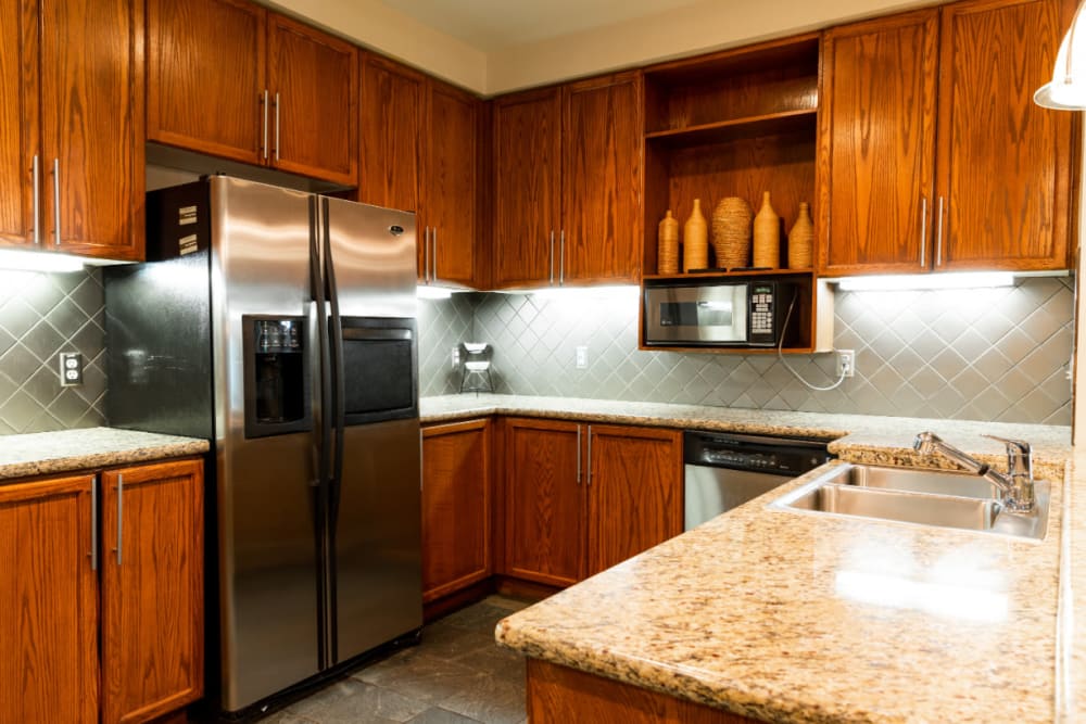 Community clubhouse kitchen with stainless steel appliances and cabinets at Marquis at Texas Street in Dallas, Texas