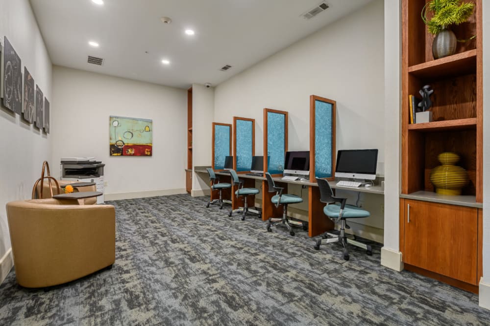 Executive business center with multiple workstations and commercial printer at Sabina in Austin, Texas