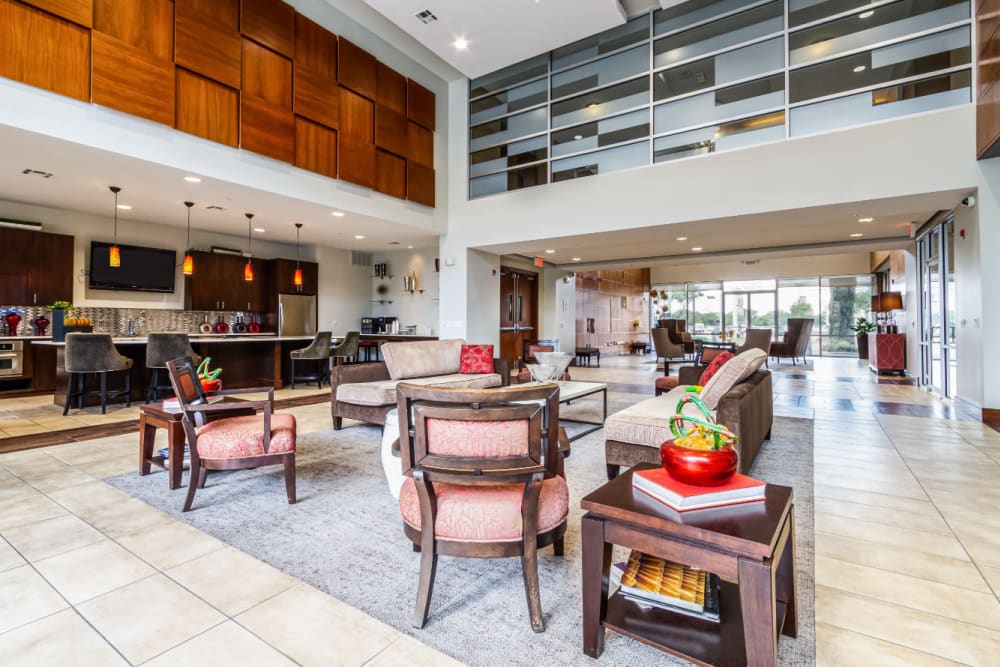 Community clubhouse seating area with kitchen in background at The Marq on Voss in Houston, Texas