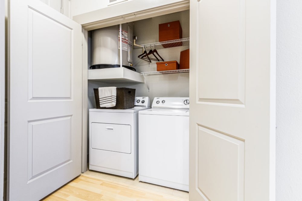 Laundry closet with full size washer and dryer and wired shelves at The Marq on Voss in Houston, Texas