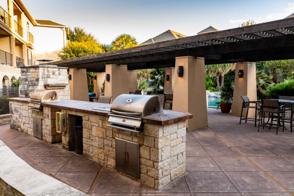 Stainless steel BBQs set in stone with dining section behind at Marquis at Great Hills in Austin, Texas