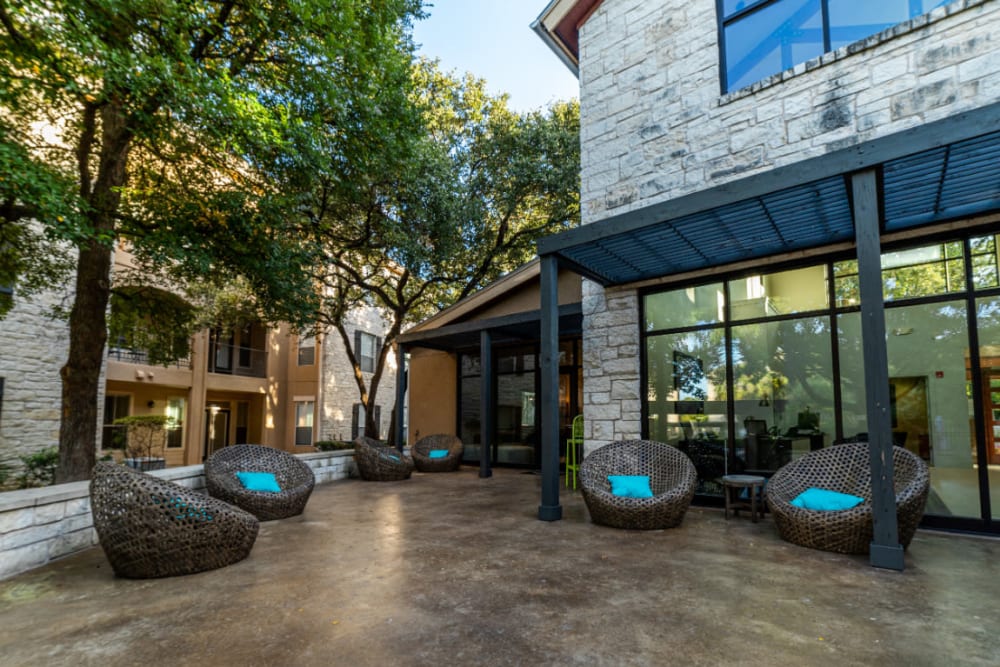 Wicker chairs with cushions in outdoor seating area at Marquis at Great Hills in Austin, Texas