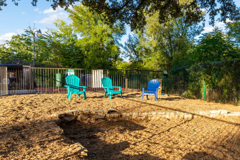 Enclosed dog park area with chairs and dog waste station at Marquis at Great Hills in Austin, Texas