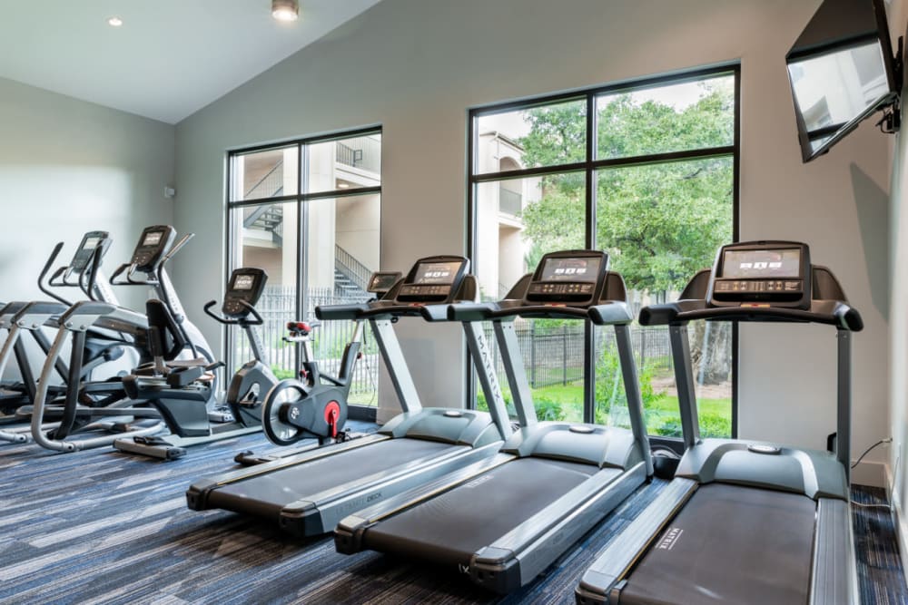 Treadmills, ellipticals, and bike machines in fitness room at Marquis at Great Hills in Austin, Texas