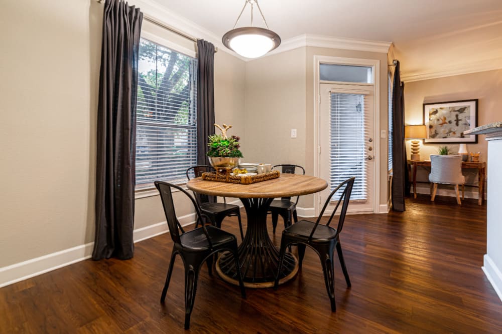 Dining table and chairs with large window and wood flooring at Marquis at Great Hills in Austin, Texas