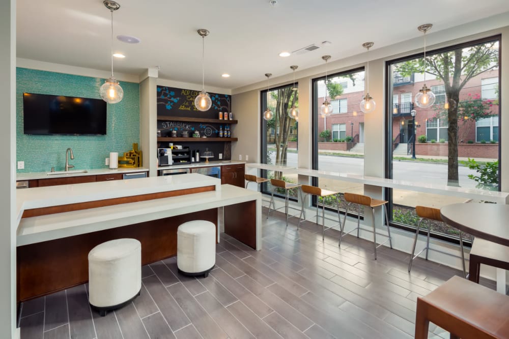 Community clubhouse kitchen, self-serve coffee bar, and counter seating against window at Marq on Ponce in Atlanta, Georgia