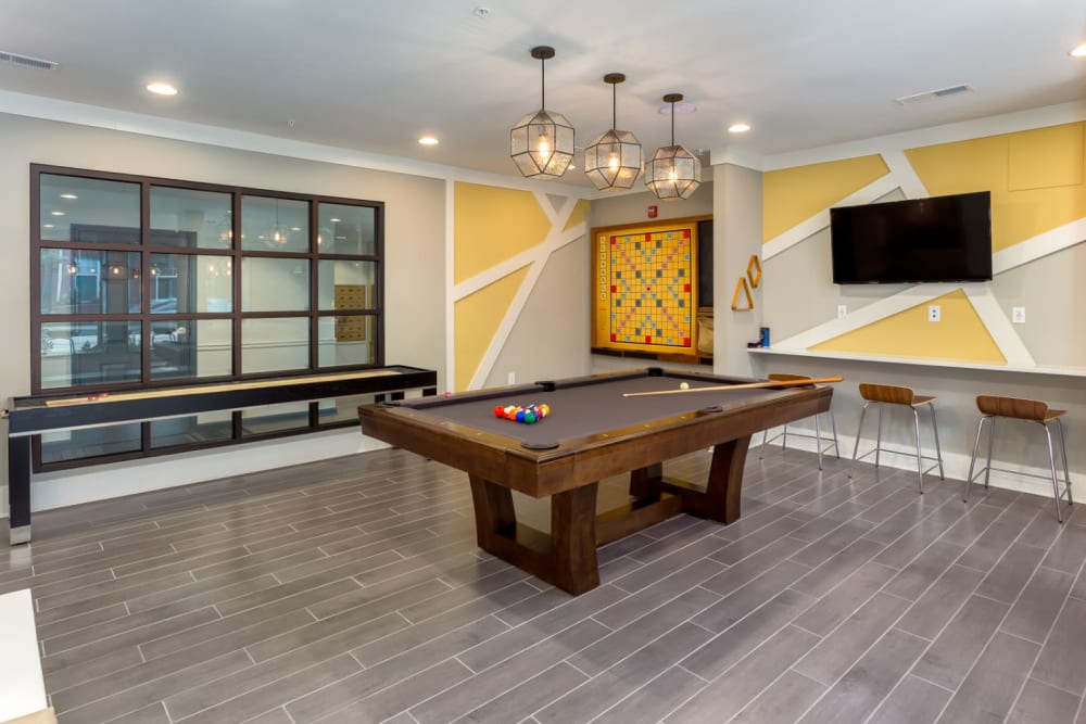 Pool table, shuffleboard, and wall-mounted scrabble in community clubhouse at Marq on Ponce in Atlanta, Georgia