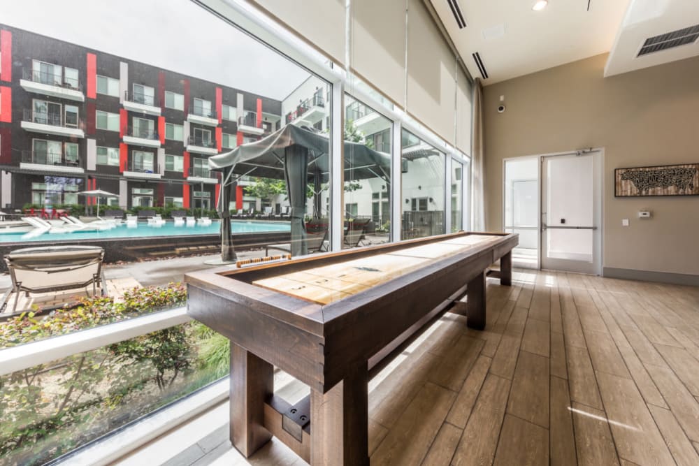 Shuffleboard next to window with view of pool deck at Marq on Burnet in Austin, Texas