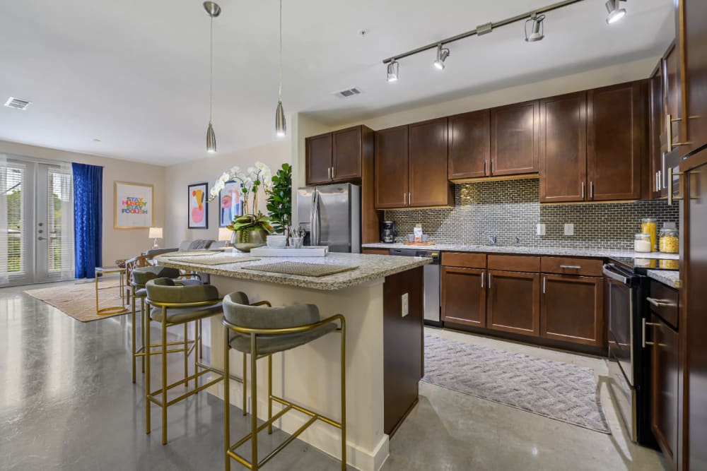 Spacious kitchen with granite counter island and stool chairs at The 704 in Austin, Texas