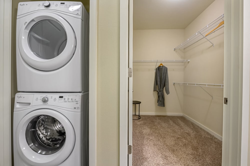 Stacked washer and dryer next to walk-in closet with wired organizer at The 704 in Austin, Texas