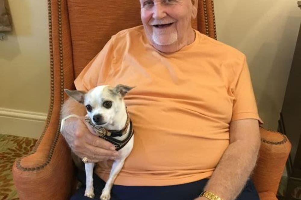 Resident holding dog at pet friendly assisted living community in Windermere, Florida | Pathway to Living