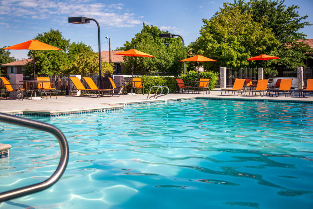 Beautiful resort-style swimming pool with lounge chairs at Shadowbrook Apartments in West Valley City, Utah