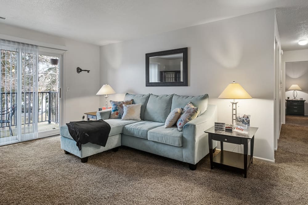 Spacious living room with wall to wall carpeting in a home at Arbors of Battle Creek Apartments & Townhomes in Battle Creek, Michigan