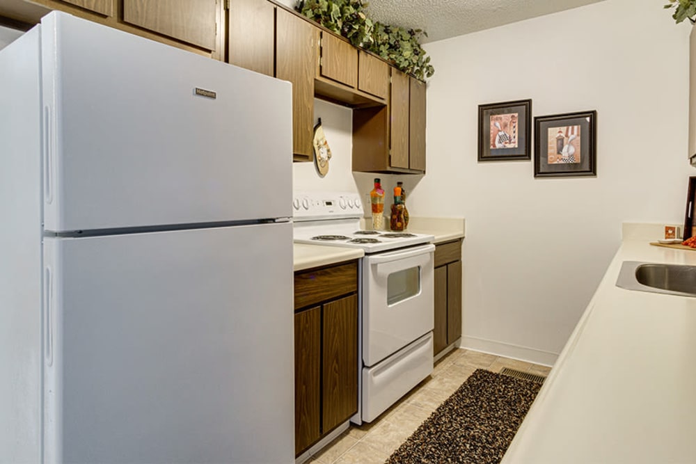 A kitchen with white appliances in a home at Briarcliffe Apartments & Townhomes in Lansing, Michigan