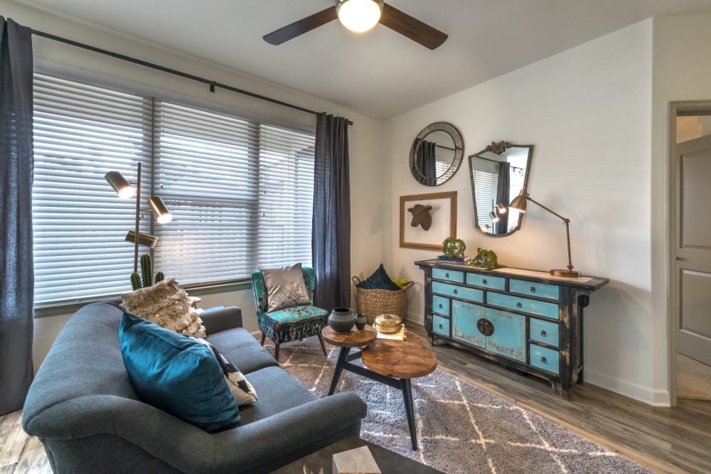 Cozy living room with large windows bringing in tons of natural light at Mercantile River District in Fort Worth, Texas