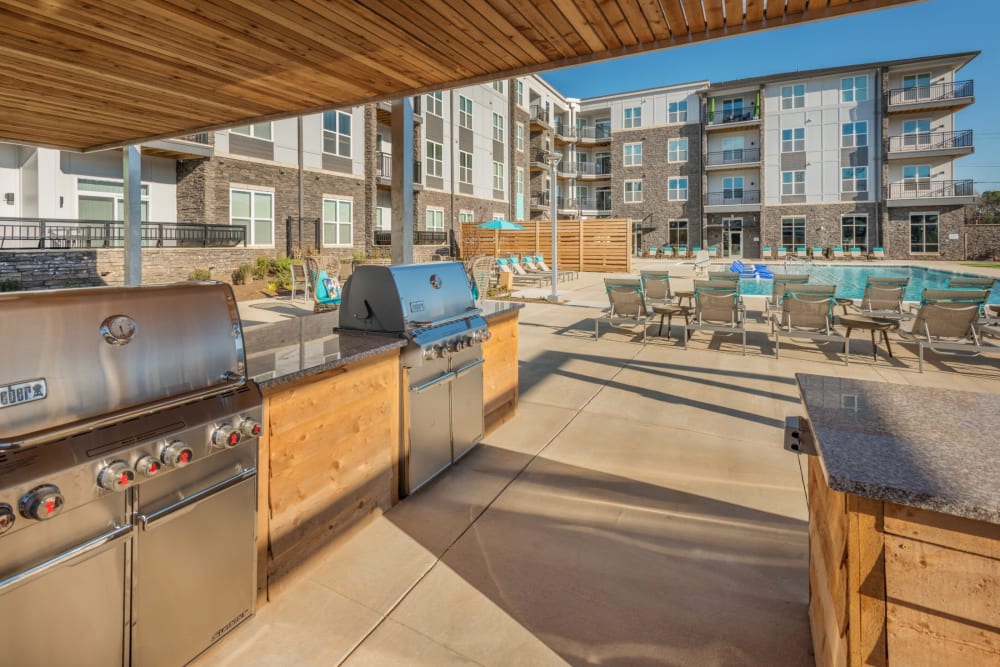 Grilling area next to the pool with tons of space to cook, eat, and relax at Blu at Northline Apartments in Charlotte, North Carolina