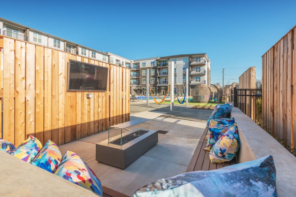 Outdoor fire pit area with tv on the wall at Blu at Northline Apartments in Charlotte, North Carolina