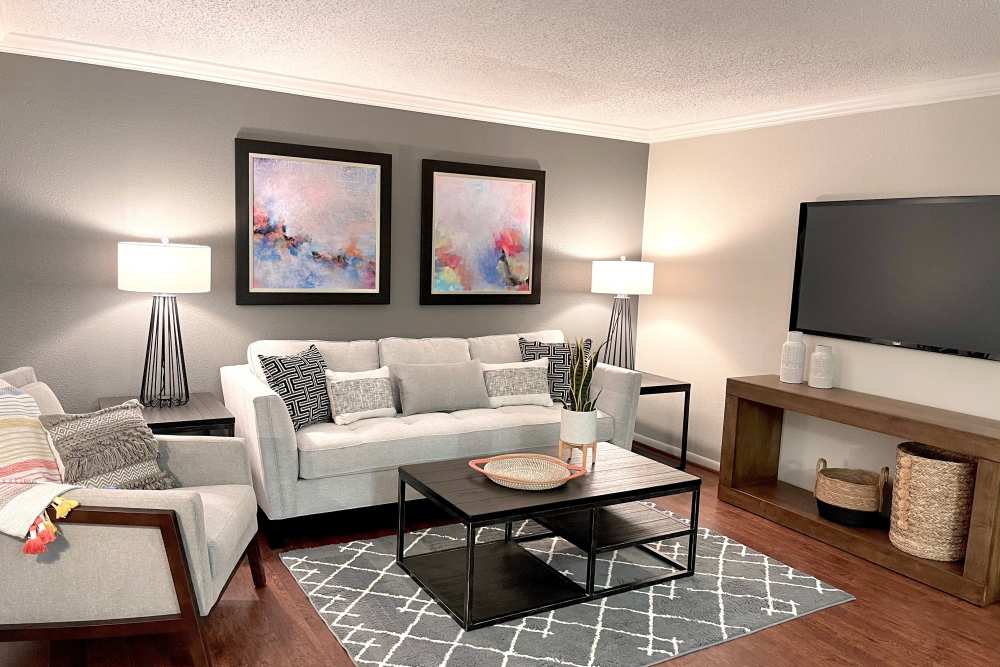 Cozy living room with fancy furniture and wood-style flooring at The Abbey at Briargrove Park in Houston, Texas