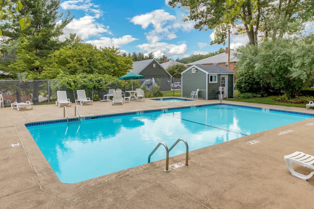 Beautiful blue pool with lounge chairs at Eagle Rock Apartments at Nashua in Nashua, New Hampshire