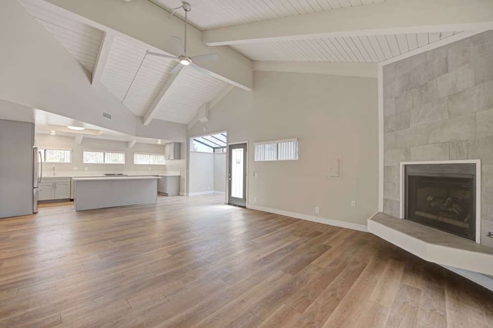 Spacious open living area with vaulted ceiling, wood-style floors, and a fireplace at Sofi Ventura in Ventura, California