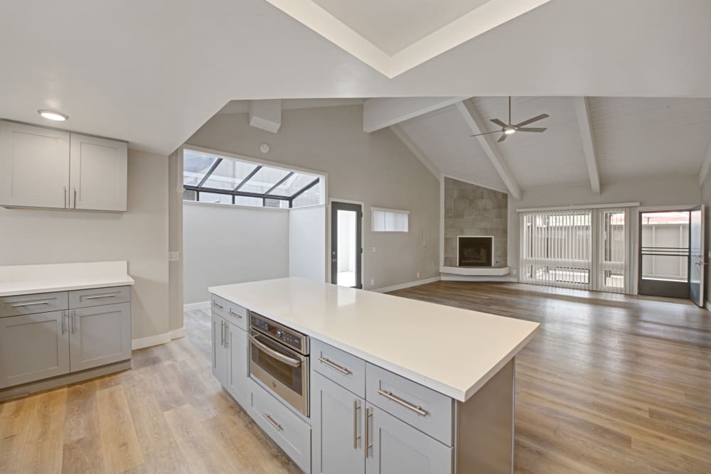 Kitchen island with built-in microwave and a spacious living area with fireplace at Sofi Ventura in Ventura, California