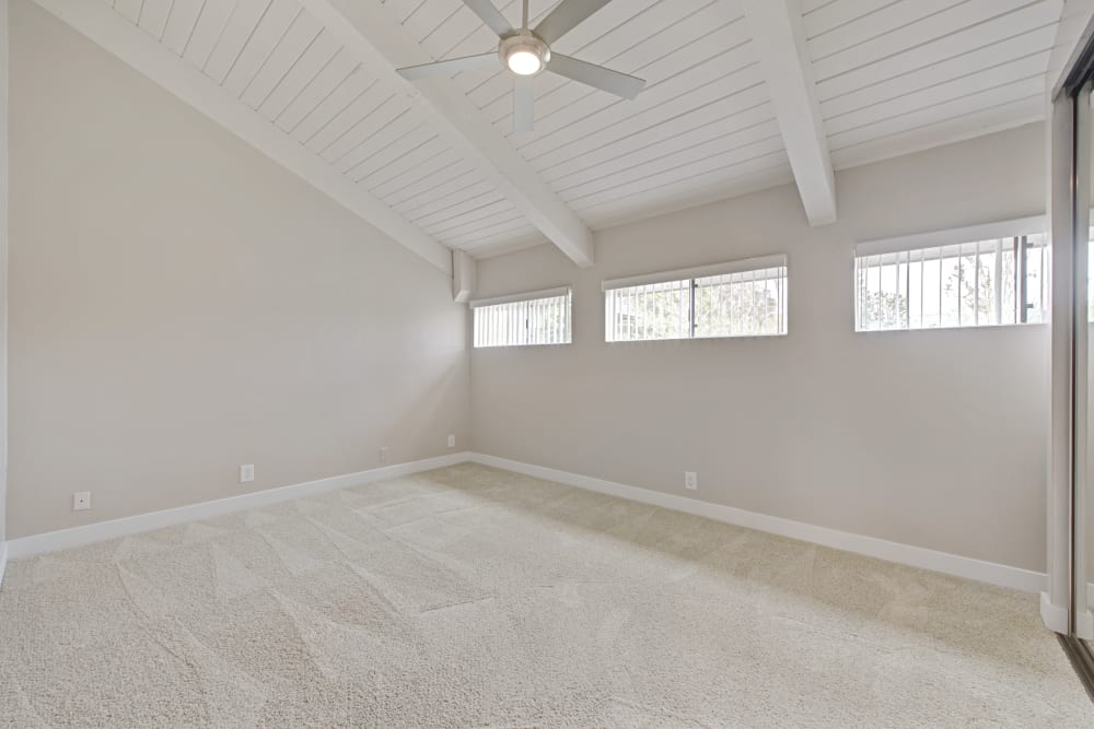 Large bedroom with vaulted ceilings, plush carpeting, and a ceiling fan at Sofi Ventura in Ventura, California