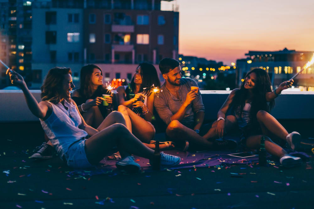 Resident friends gathered at the rooftop Sky Lounge at dusk at IDENTITY Logan Park in Berkeley, California