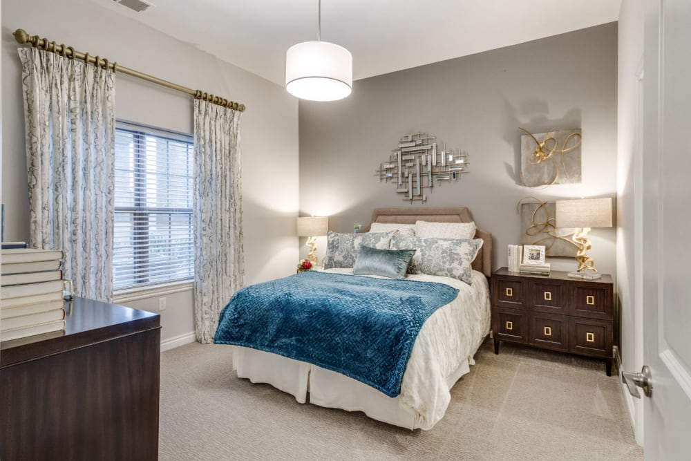 Large bedroom with art on the walls and a full-size bed in the center at Blossom Ridge in Oakland Charter Township, Michigan