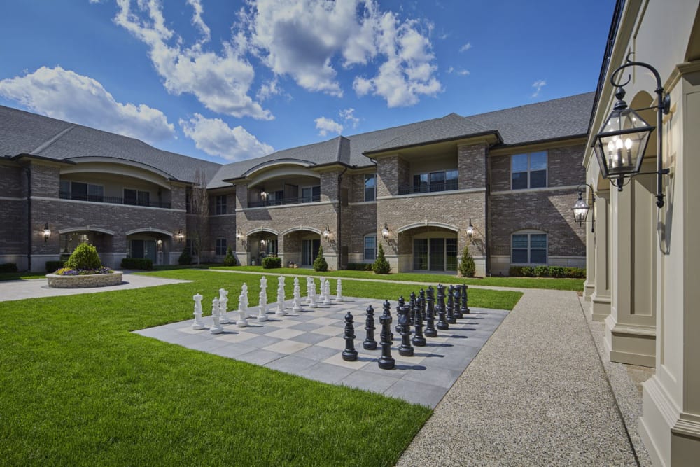 Central courtyard with a giant chess set and several paved walking paths at Blossom Ridge in Oakland Charter Township, Michigan