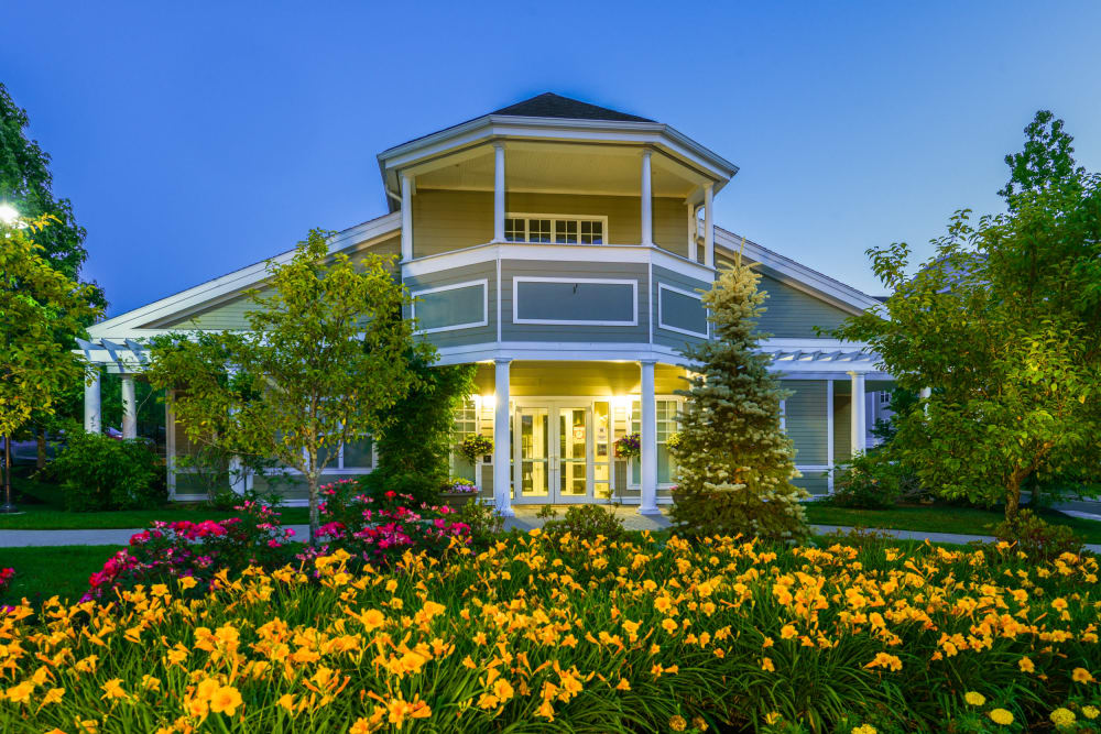 Clubhouse and leasing center entrance with grand flower bed in front at Sofi Danvers in Danvers, Massachusetts